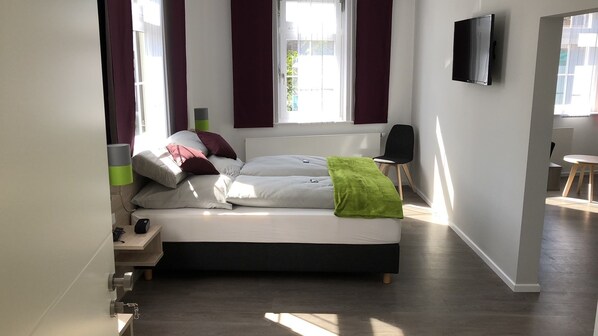 A modern bedroom with a bed, a TV, and a window. - Landhotel Zur Bretzel (Babenhausen)