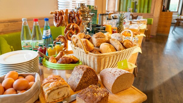 Un buffet de petit-déjeuner proposant une variété de pains, de viennoiseries et d’accompagnements.