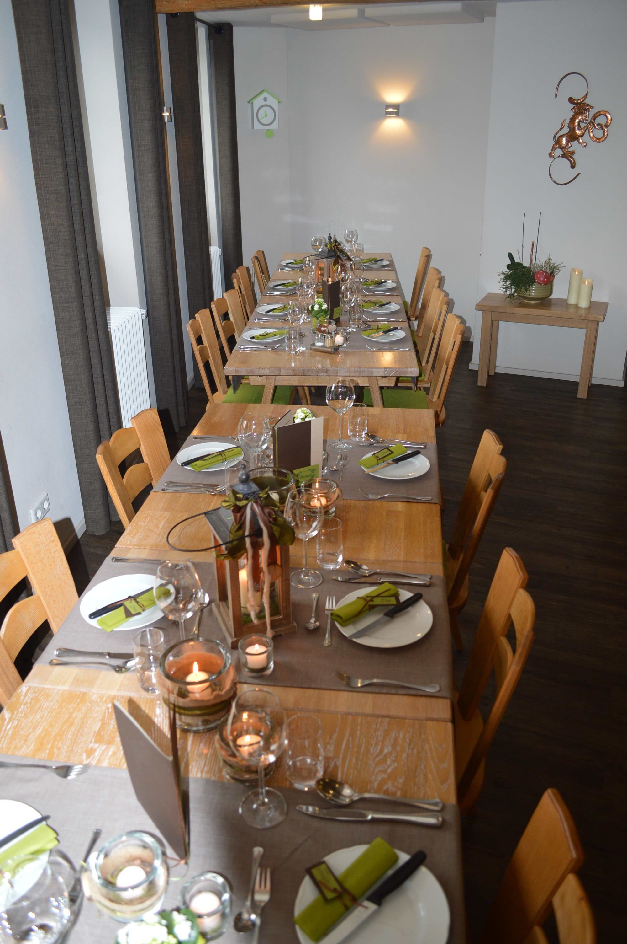 A long dining table set with multiple chairs, candles, and a decorative centerpiece.