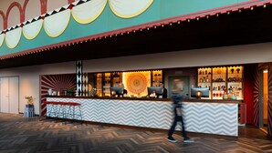 Een receptiegedeelte met een schouderpartij-patroon toonbank, barstoelen en een decoratief plafond.