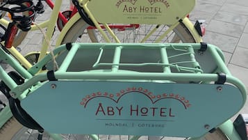 A bicycle with a green frame and a sign that reads "ABY Hotel" and "Mölndal | Goteborg".