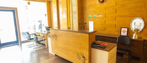 Una recepción con detalles de madera, un reloj en la pared y un abanico decorativo.