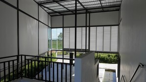 Un interior moderno con balcón, ventanas amplias y barandilla de metal.