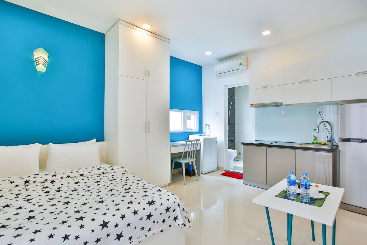 Una habitación de hotel moderna con cama, escritorio y kitchenette.