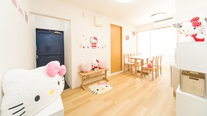 A room with a wooden floor, a bench, a table with chairs, and a door.