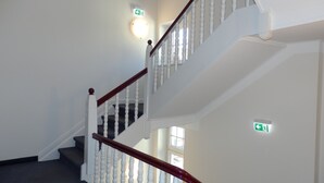 A multi-level staircase with white balusters and a wooden handrail. - Hotel Bellevue (Hamelin)