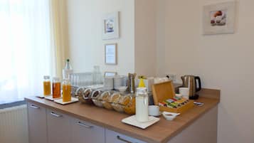 A breakfast buffet setup with various food items and beverages.