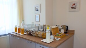 A breakfast buffet setup with various food items and beverages. - Hotel Bellevue (Hamelin)