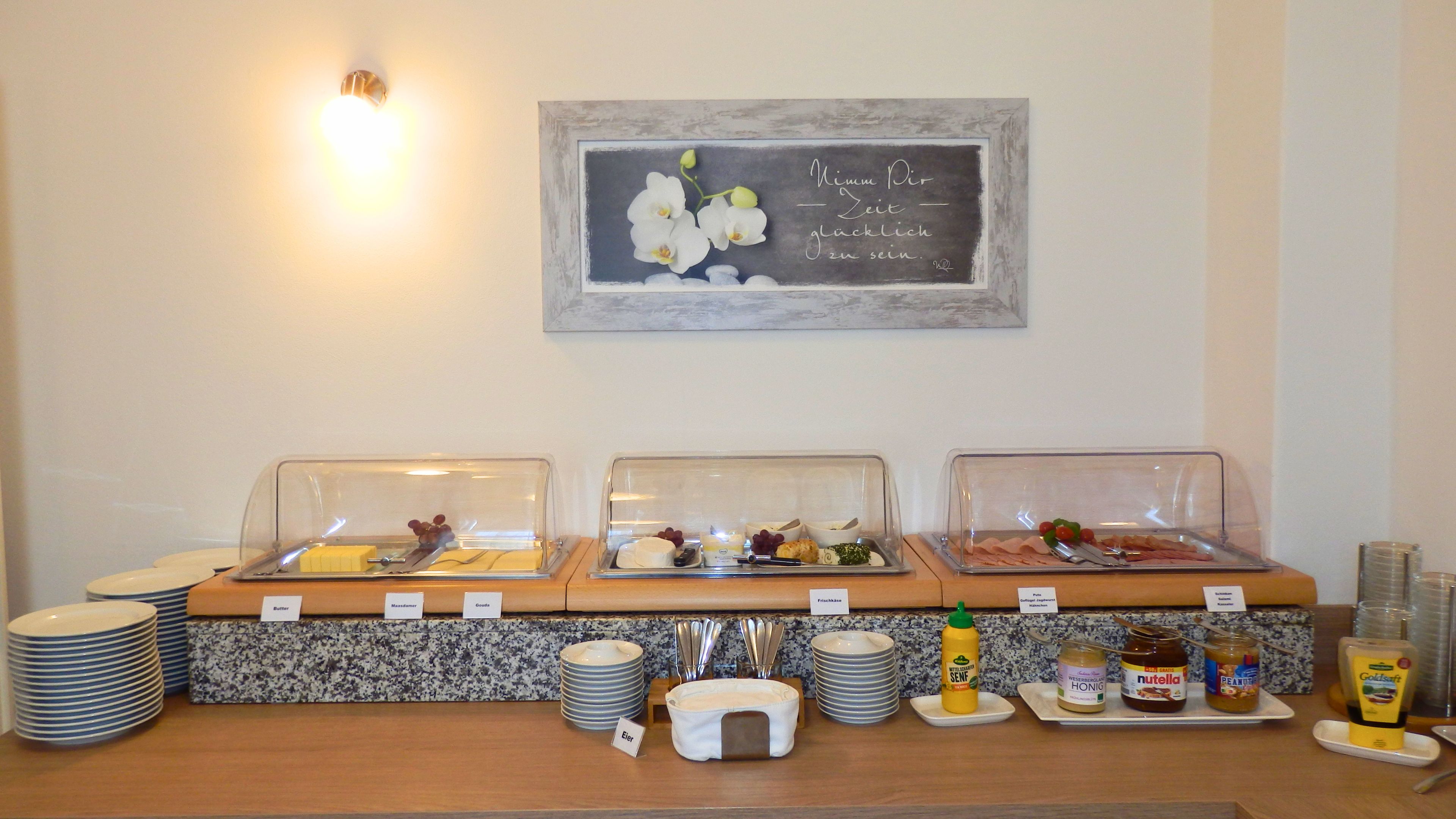 A breakfast buffet setup with labeled food items and condiments.