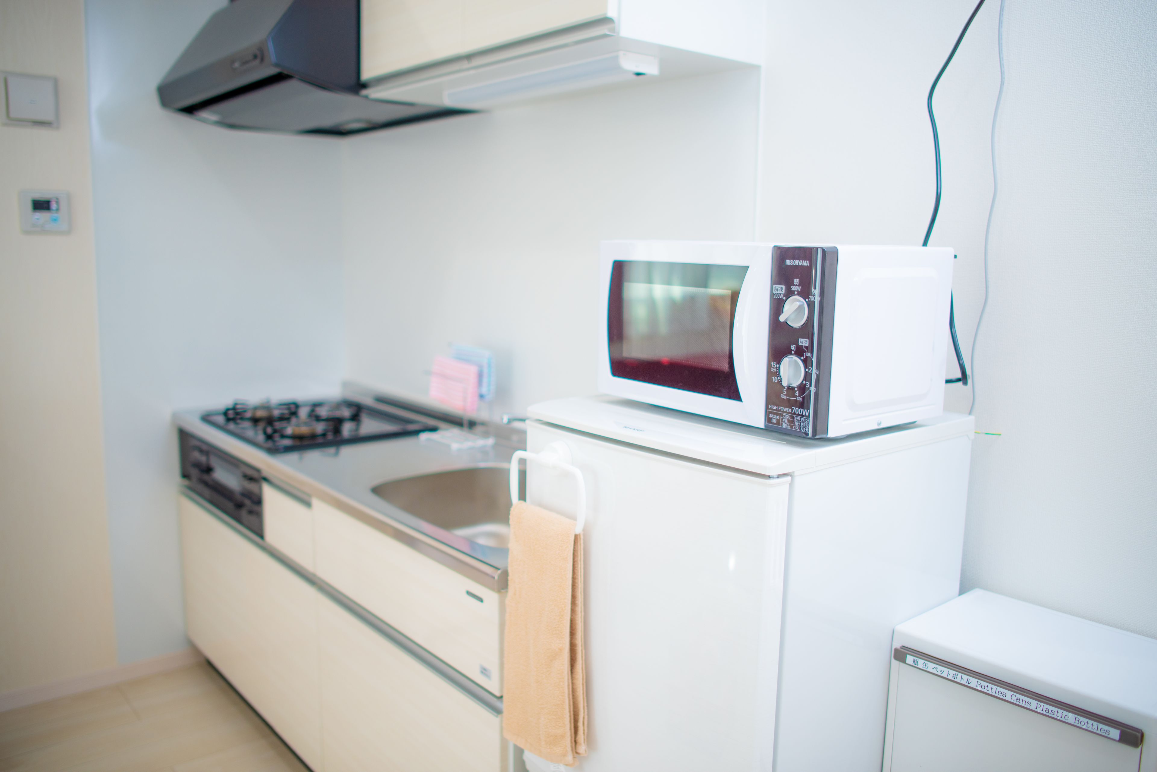 A compact kitchen with a gas stove, a microwave, and a small refrigerator.