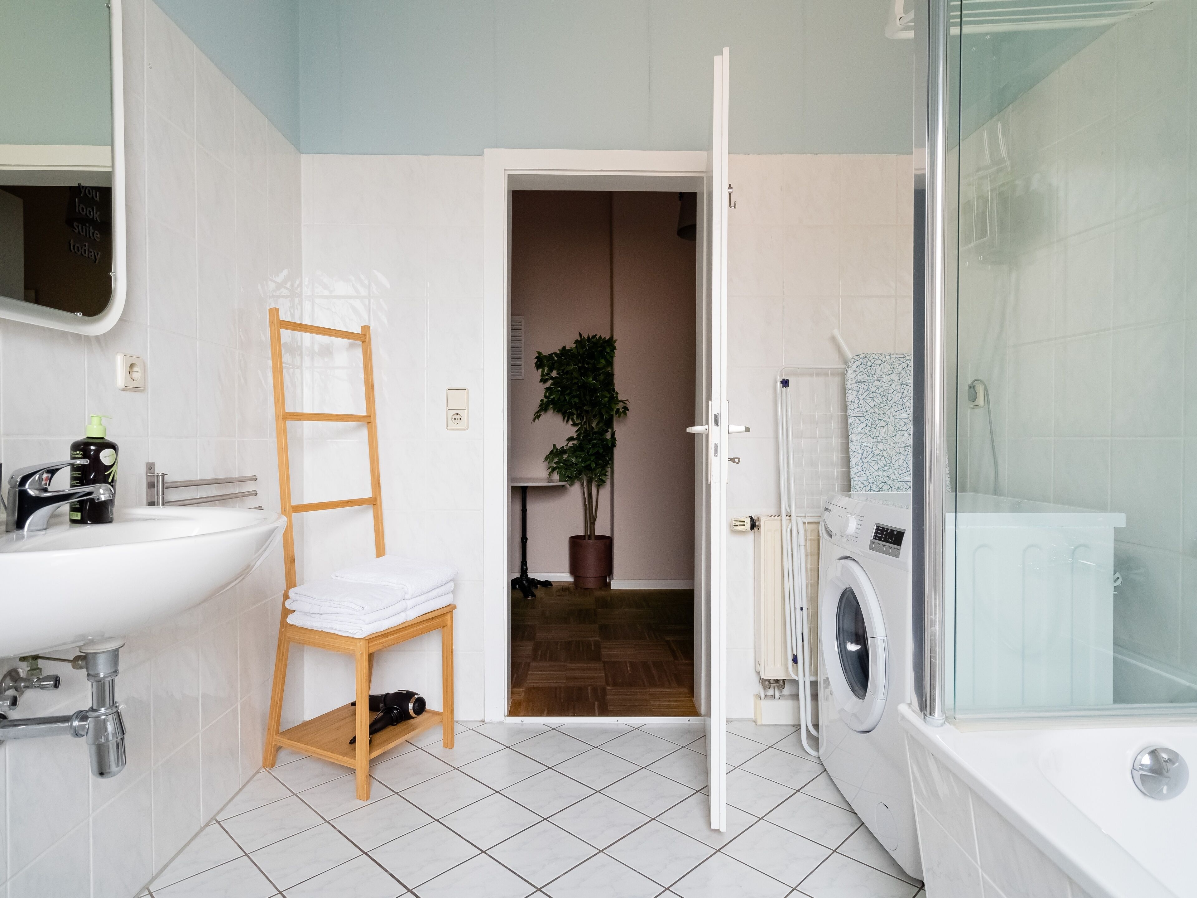 Une salle de bain moderne équipée d’un lavabo, d’un porte-serviettes et d’un espace douche.