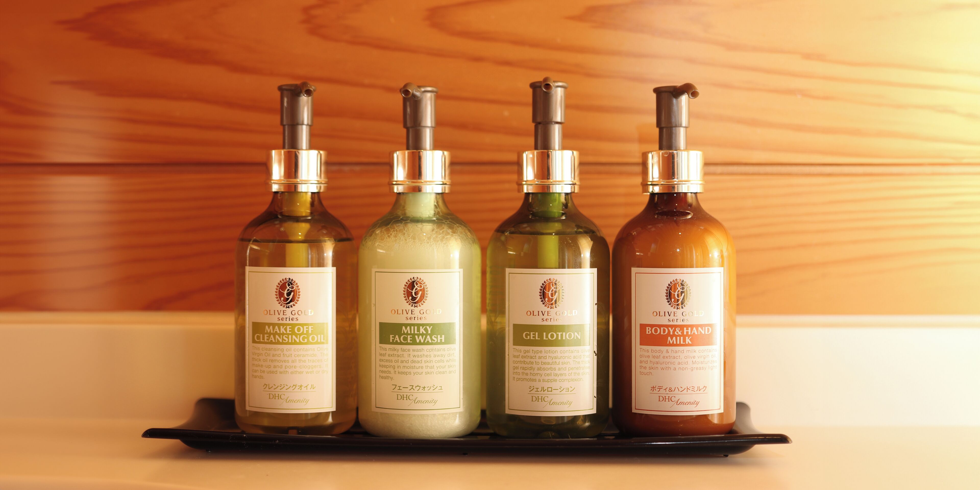 Quatre bouteilles d’huile d’olive sont posées sur une étagère.