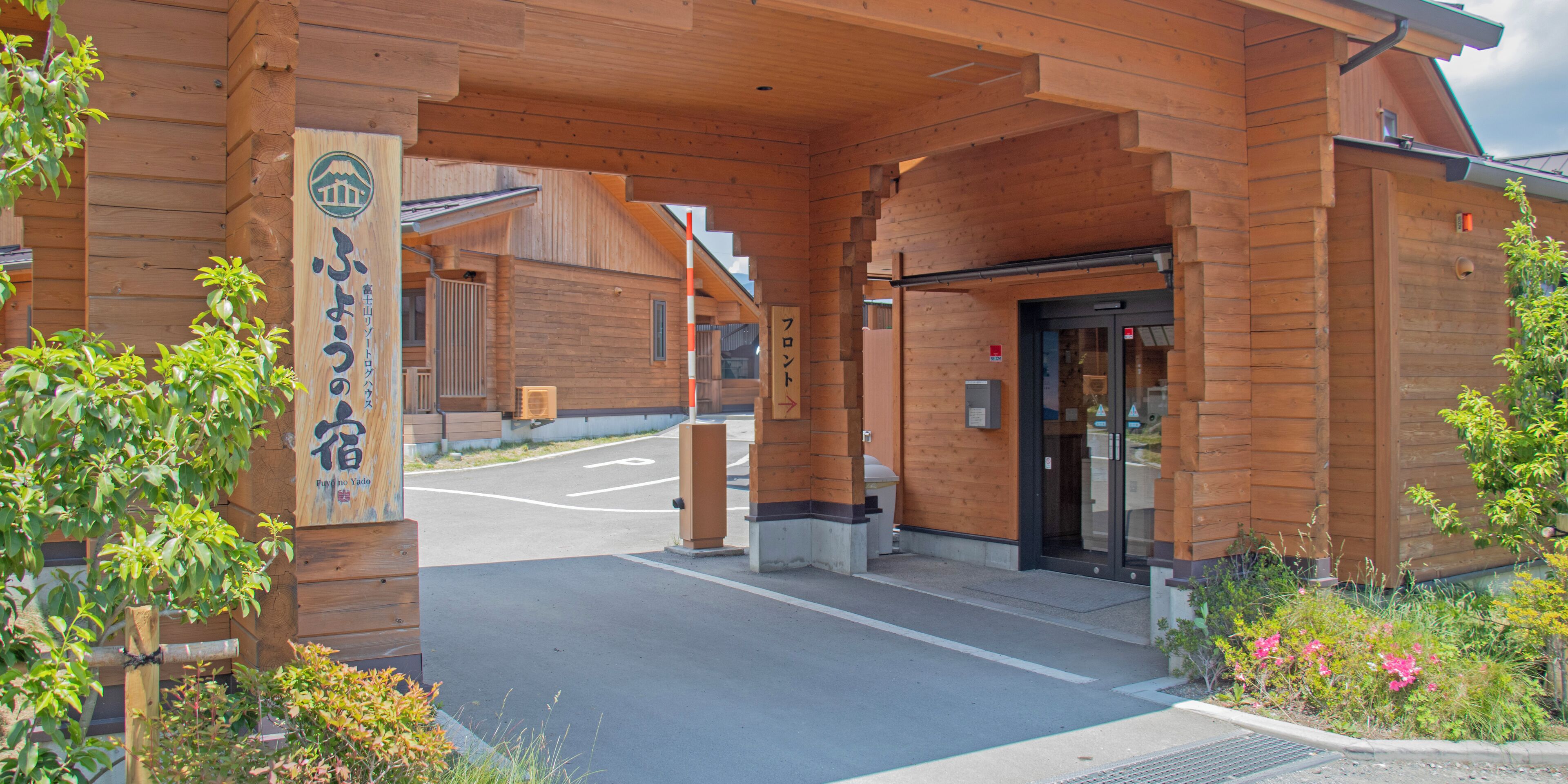 A wooden building with a covered entrance and a signboard.