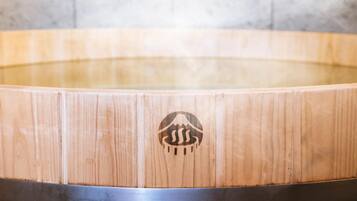 Una vasca idromassaggio in legno con un logo al centro.