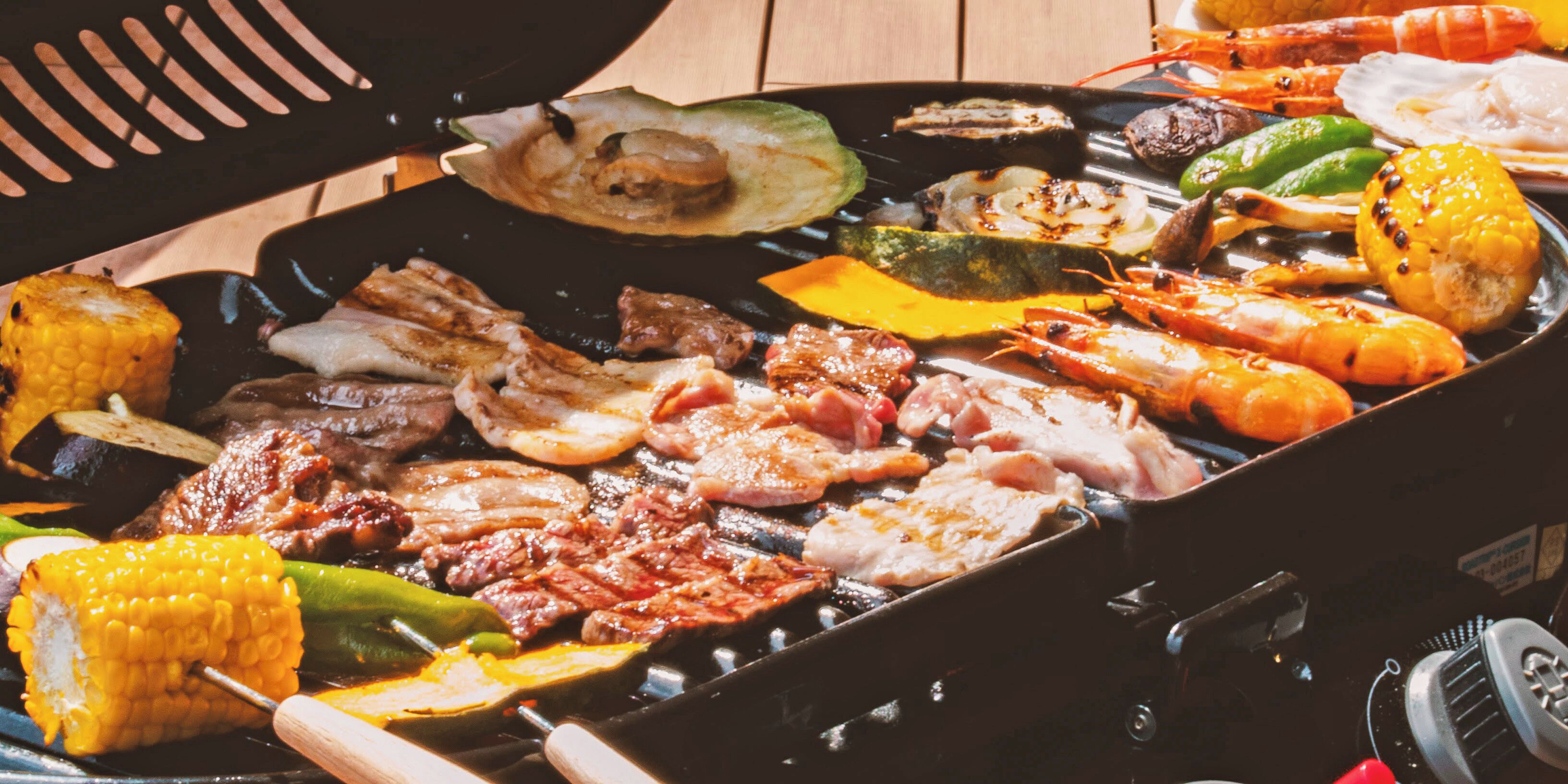 A variety of grilled meats and vegetables on a grill.