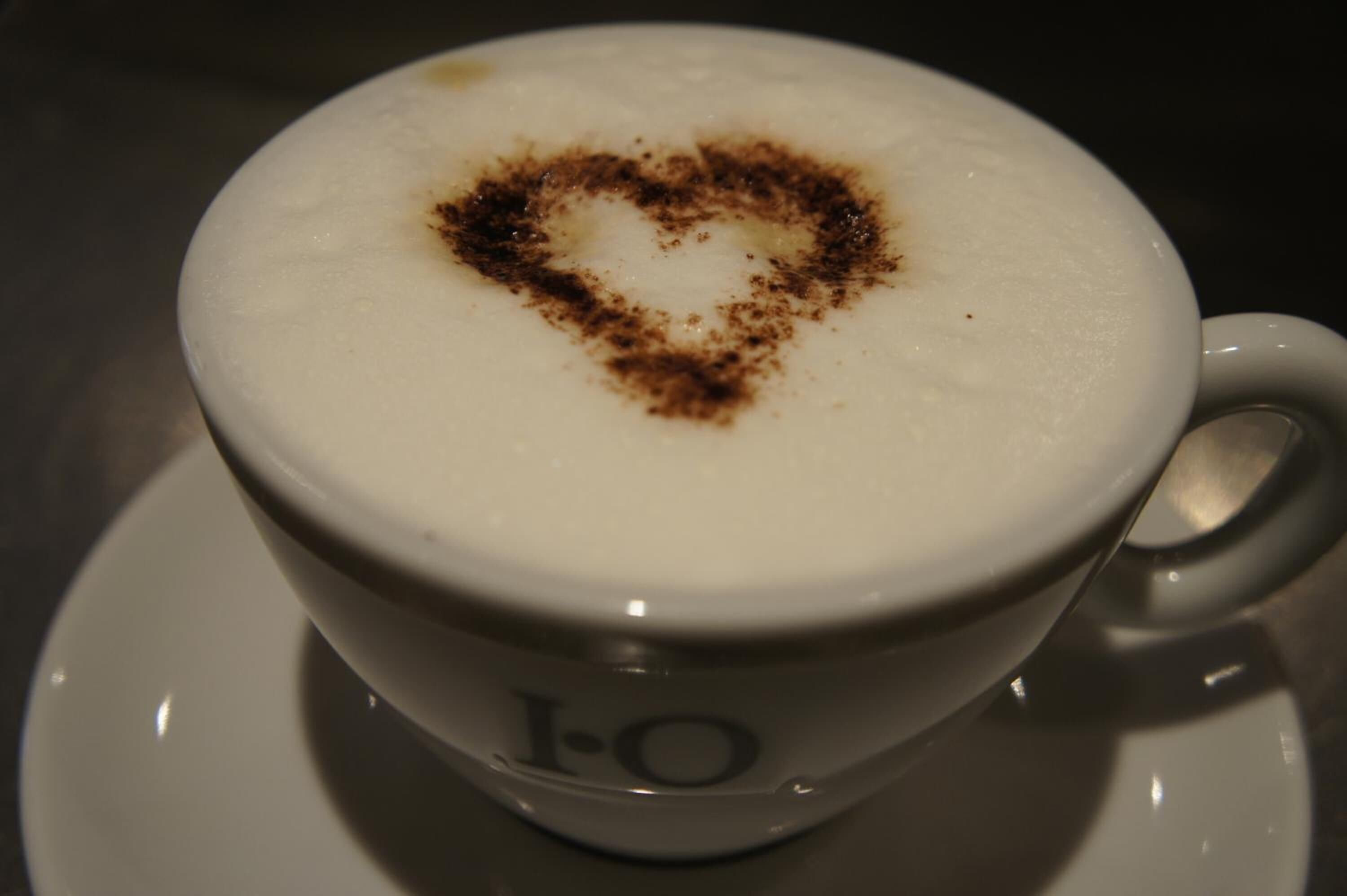 A cup of coffee with a heart-shaped design on the foam.