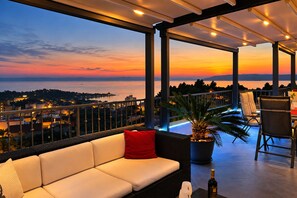 A balcony with a sofa, chairs, and a potted plant. - FLEXIBLE ARRIVAL! Fantastic penthouse with terrace and sea view, three bedrooms (Makarska)
