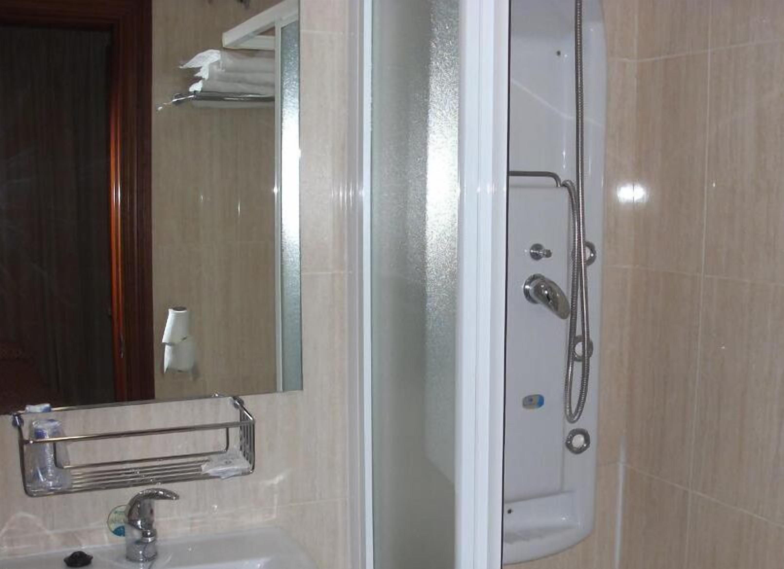 A bathroom with a bathtub, a sink, and a mirror.