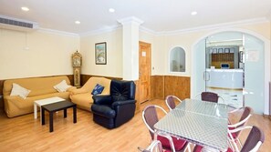 A living room with a sofa, a leather chair, a glass table, and a reception desk. - Hotel La Duquesa (Pinos Genil)