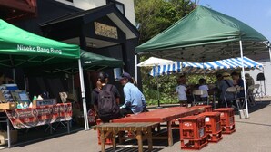 Um mercado ao ar livre com uma tenda verde identificada como "Nisekobangbangbangbangbangbangbangbangbangbangbangbangbangbangbangbangbangbangbangbangbangbangbangbangbangbangbangbangbangbangbangbangbangbangbangbangbangbangbangbangbangbangbangbangbangbangbangbangbangbangbangbangbangbangbangbangbangbangbangbangbangbangbangbangbangbangbangbangbangbangbangbangbangbangbangbangbangbangbangbangbangbangbangbangbangbangbangbangbangbangbangbangbangbangbangbangbangbangbangbangbangbangbangbangbangbangbangbangbangbangbangbangbangbangbangbangbangbangbangbangbangbangbangbang".