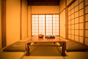 A traditional Japanese room with tatami flooring, a low wooden table, and sliding shoji doors. - HARUKIYA Hanare (Osaka)