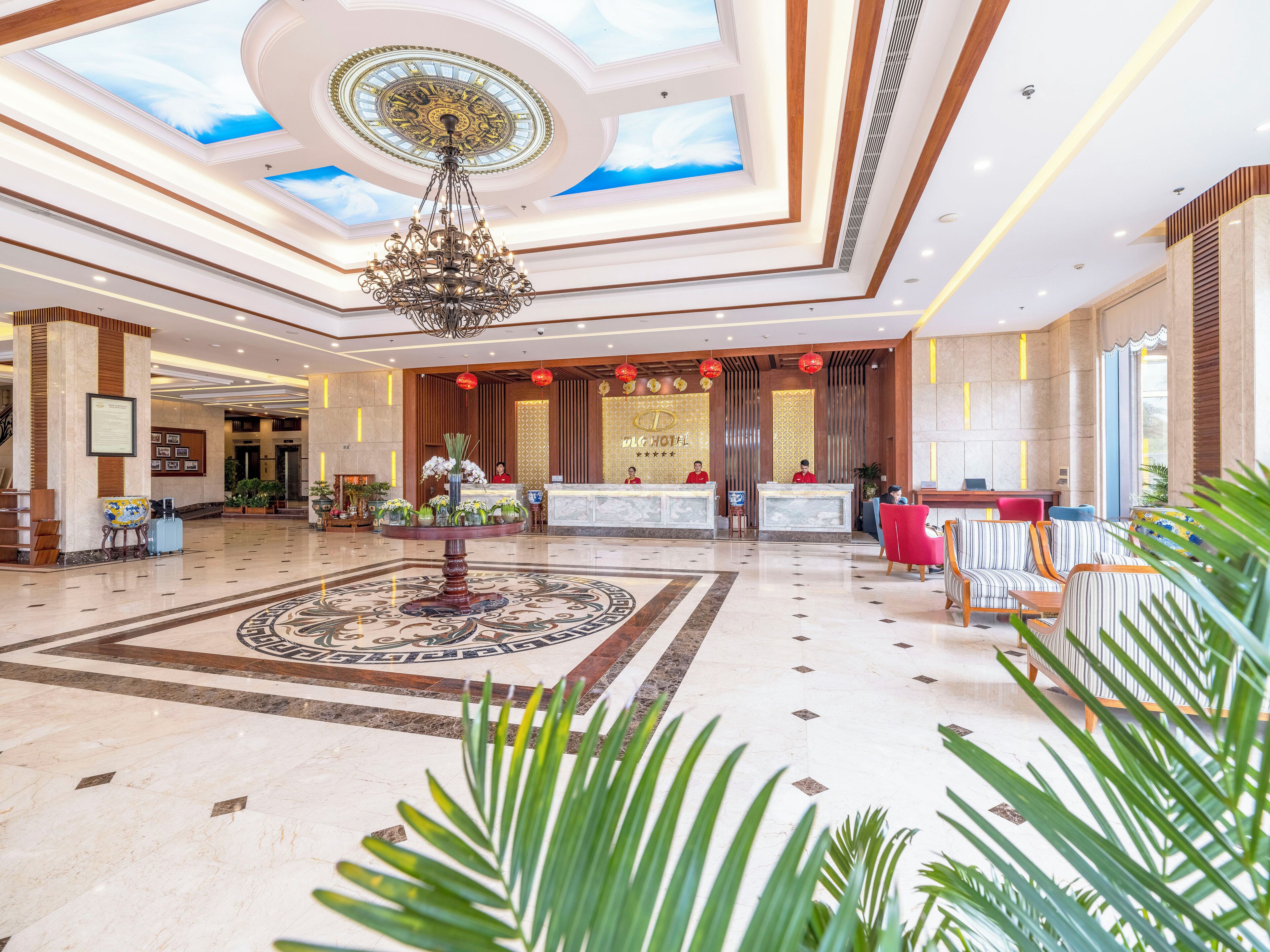 A hotel lobby with a reception desk, seating area, and a decorative fountain.