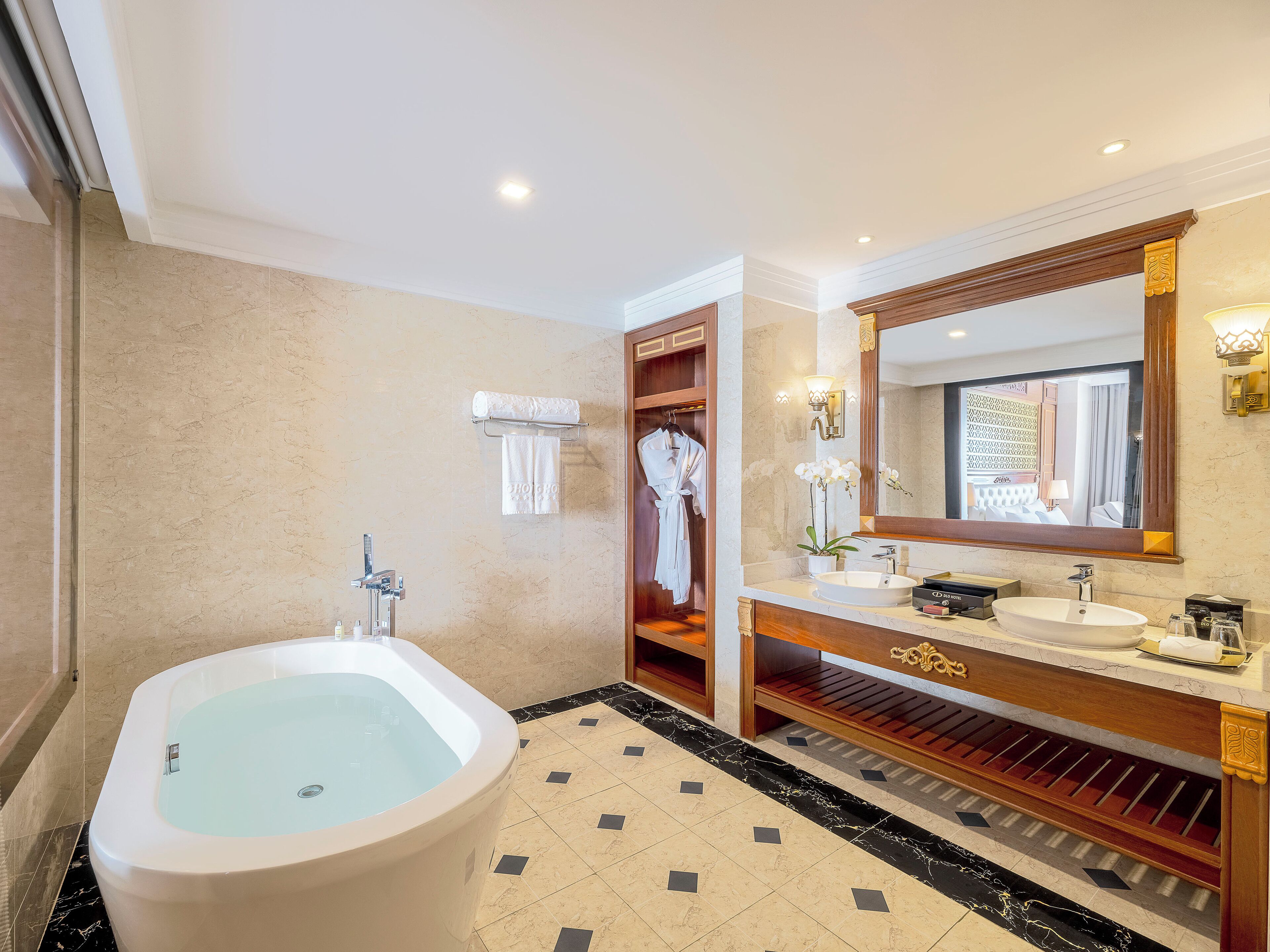 Une salle de bain moderne avec une grande baignoire, un meuble-lavabo avec un miroir et un porte-peignoir.
