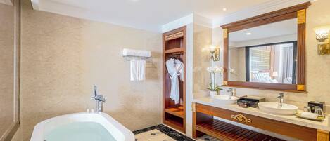 Une salle de bain moderne avec une grande baignoire, un meuble-lavabo avec un miroir et un porte-peignoir.