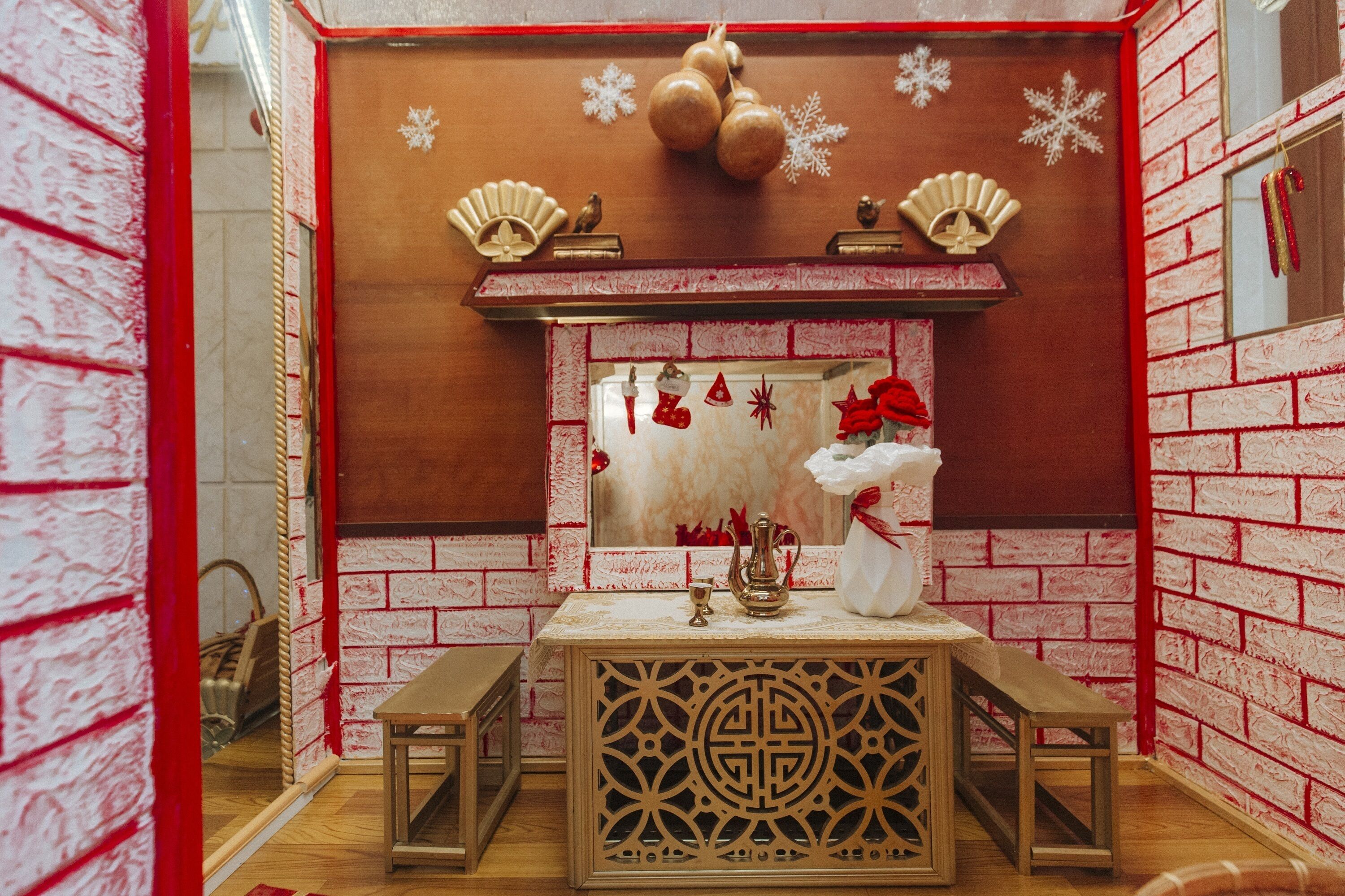 A cozy room with a wooden bench, a decorative mirror, and a small table with a candle and a vase.