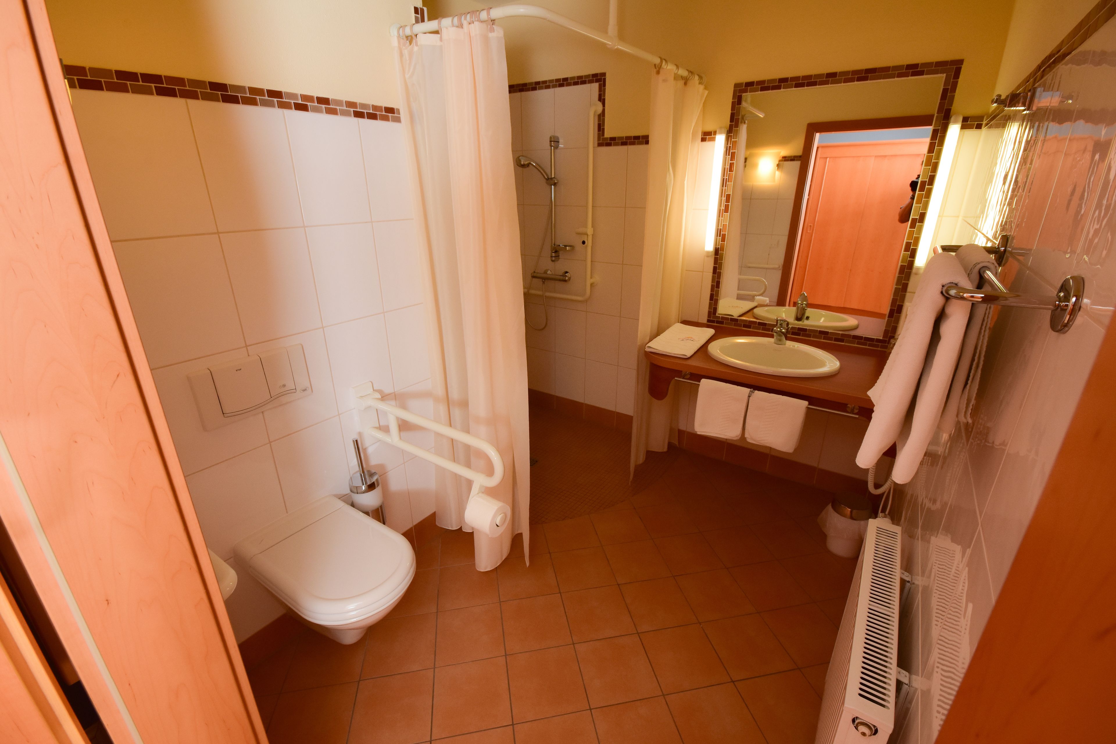 Un baño con inodoro, lavamanos, ducha y espejo.