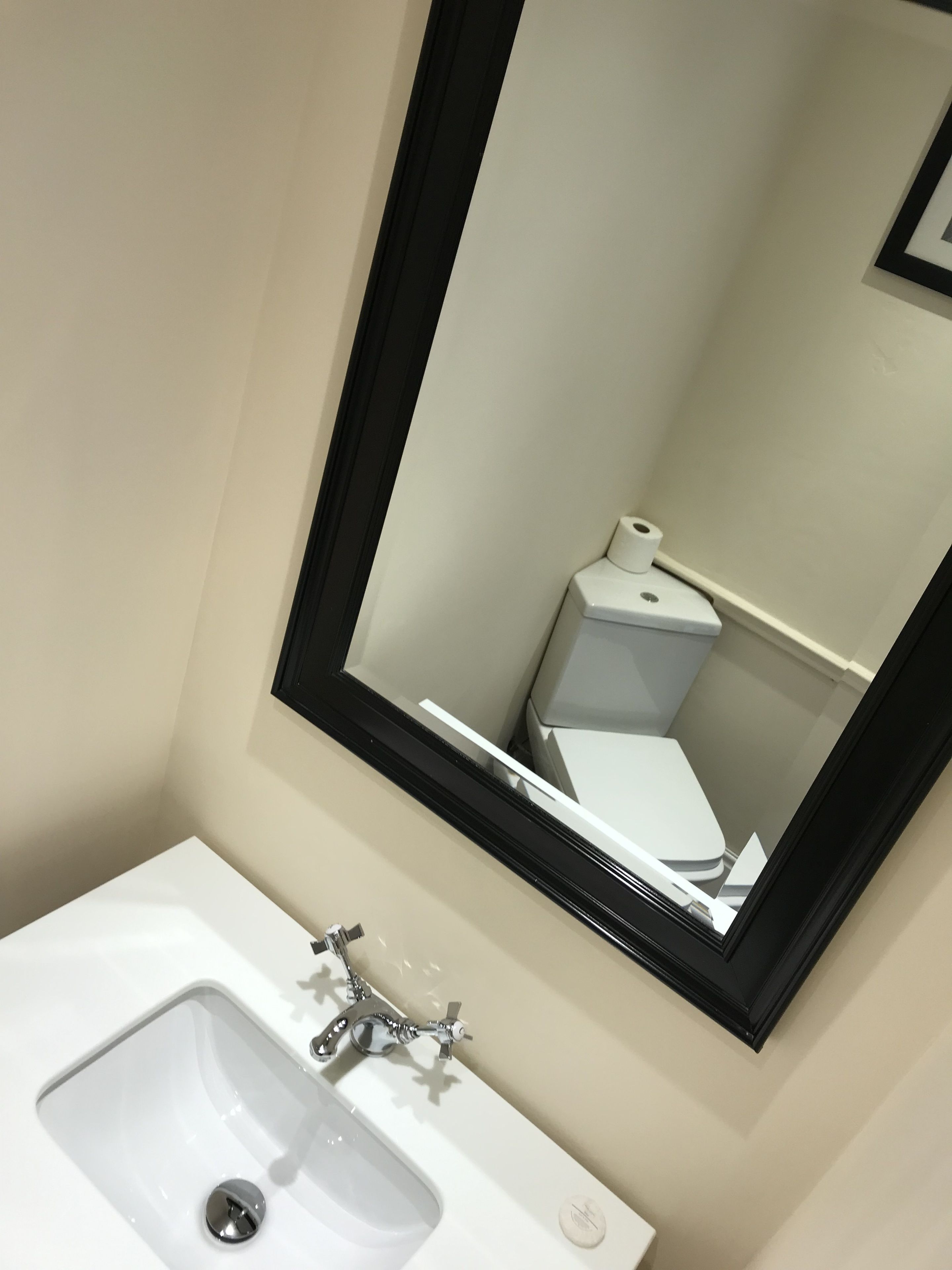 A bathroom with a white sink, a mirror, and a toilet.