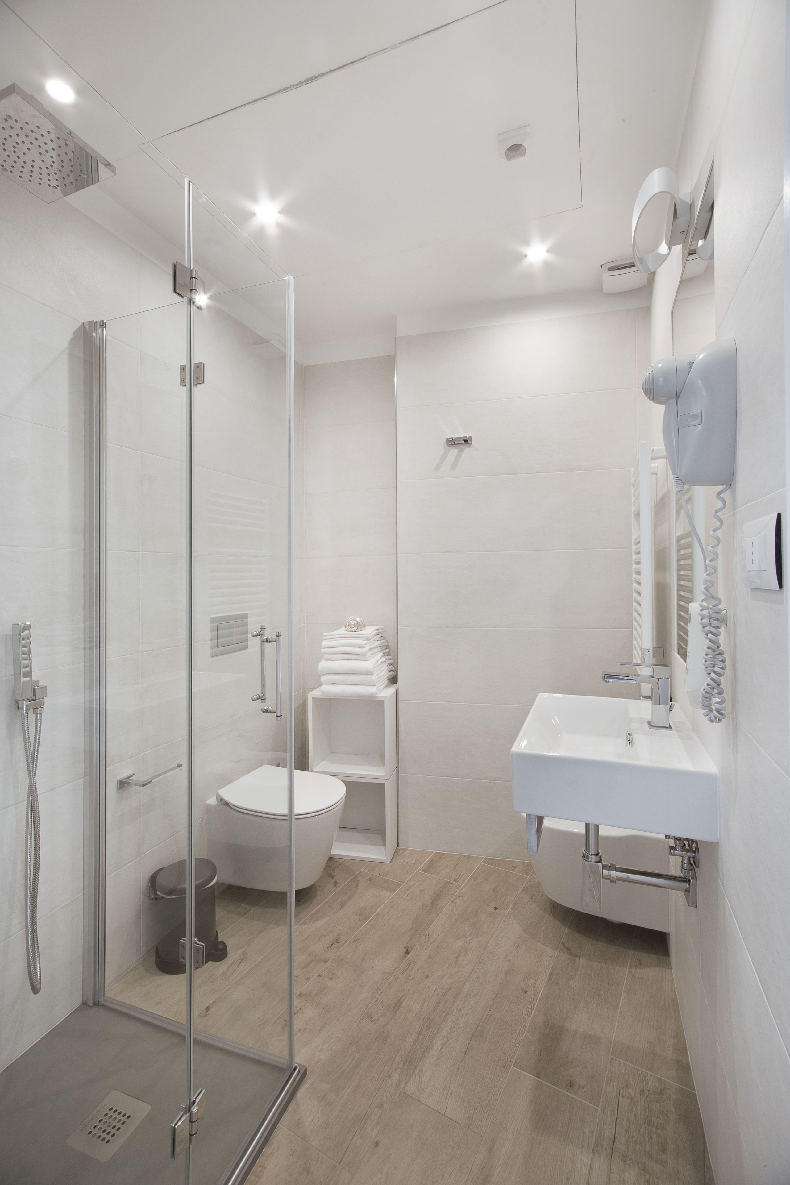 Un bagno moderno con doccia vetrata, lavandino bianco e water.