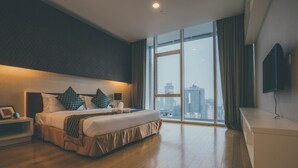 A modern hotel room with a large bed, a bedside table, a TV, and a city view. - LUMA At Platinum Suite (Kuala Lumpur)