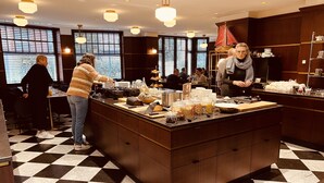 Een geruite vloer, een buffet met etenswaren en mensen in een eetruimte.