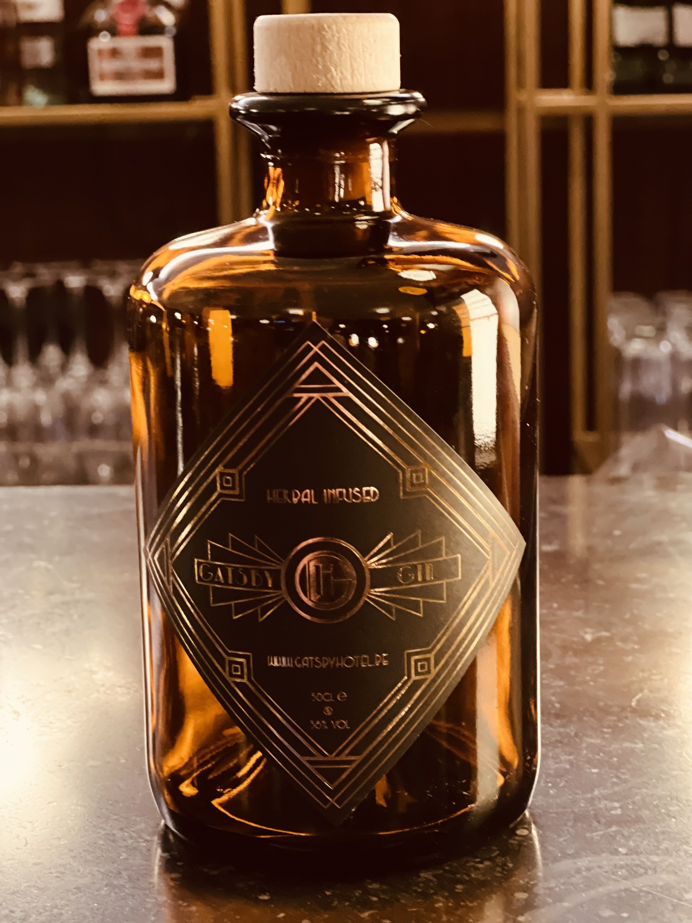 A bottle with a geometric label, placed on a bar counter.