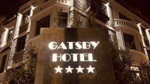 Een bord met de naam GATESBY HOTEL en een vijfsterrenbeoordeling.