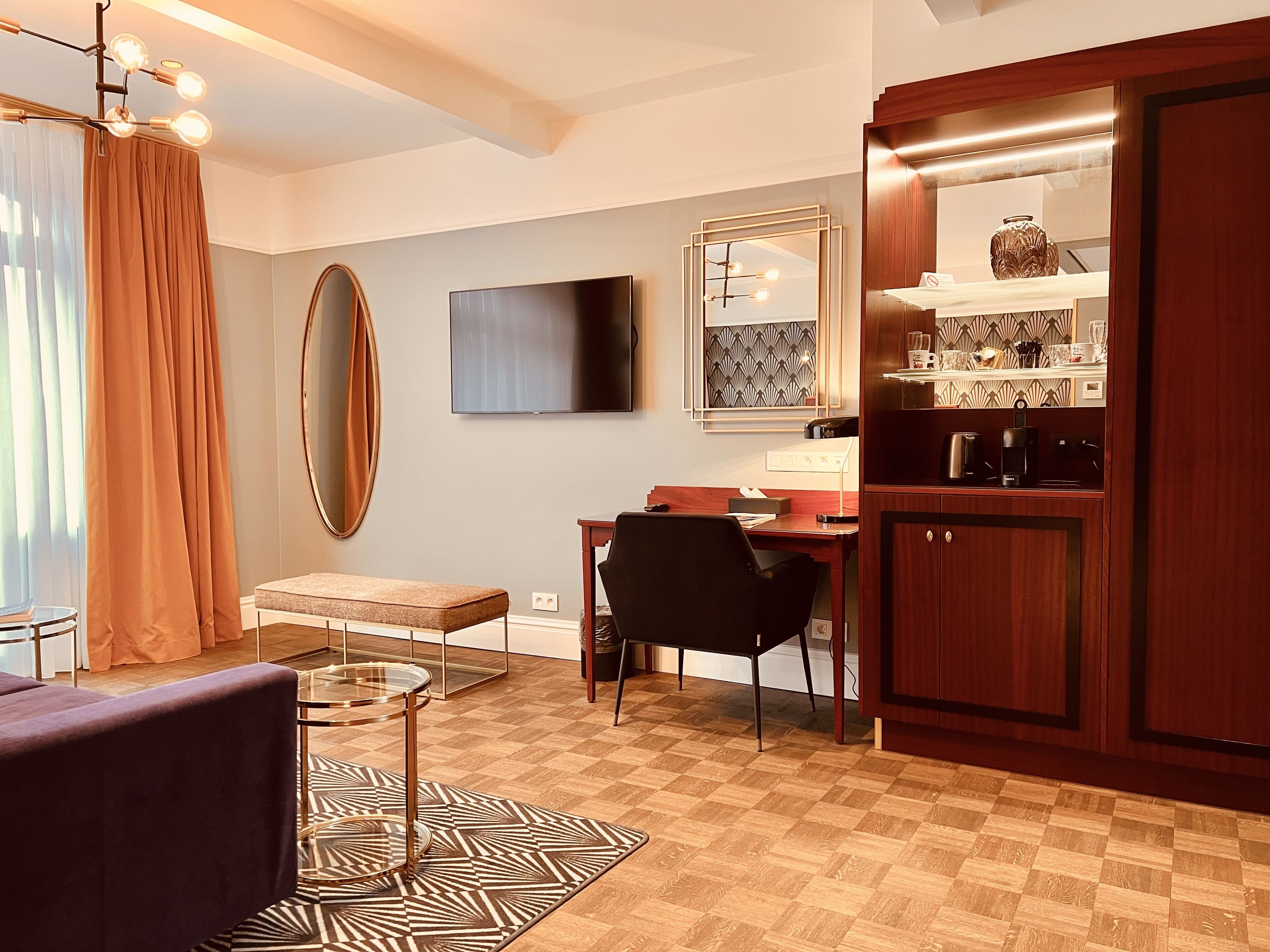 A modern kitchen with a dining area, a large mirror, and a television.