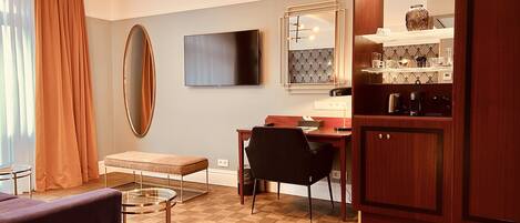 A modern kitchen with a dining area, a large mirror, and a television.