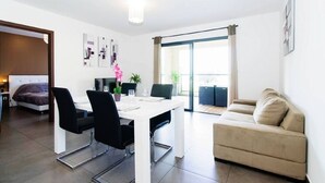 Un salon moderne comprenant un coin repas, un canapé et un balcon avec vue.