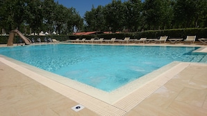 A swimming pool with lounge chairs and a slide. - Camping Viareggio (Viareggio)