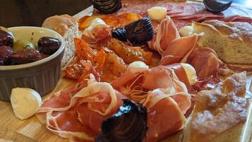 A charcuterie board with various meats, cheeses, and olives.