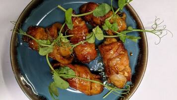A plate of glazed chicken wings garnished with microgreens.