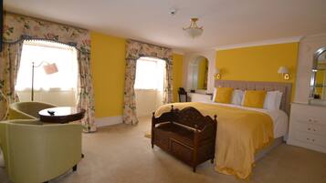 A bedroom with a bed, a chair, a bedside table, and a lamp.