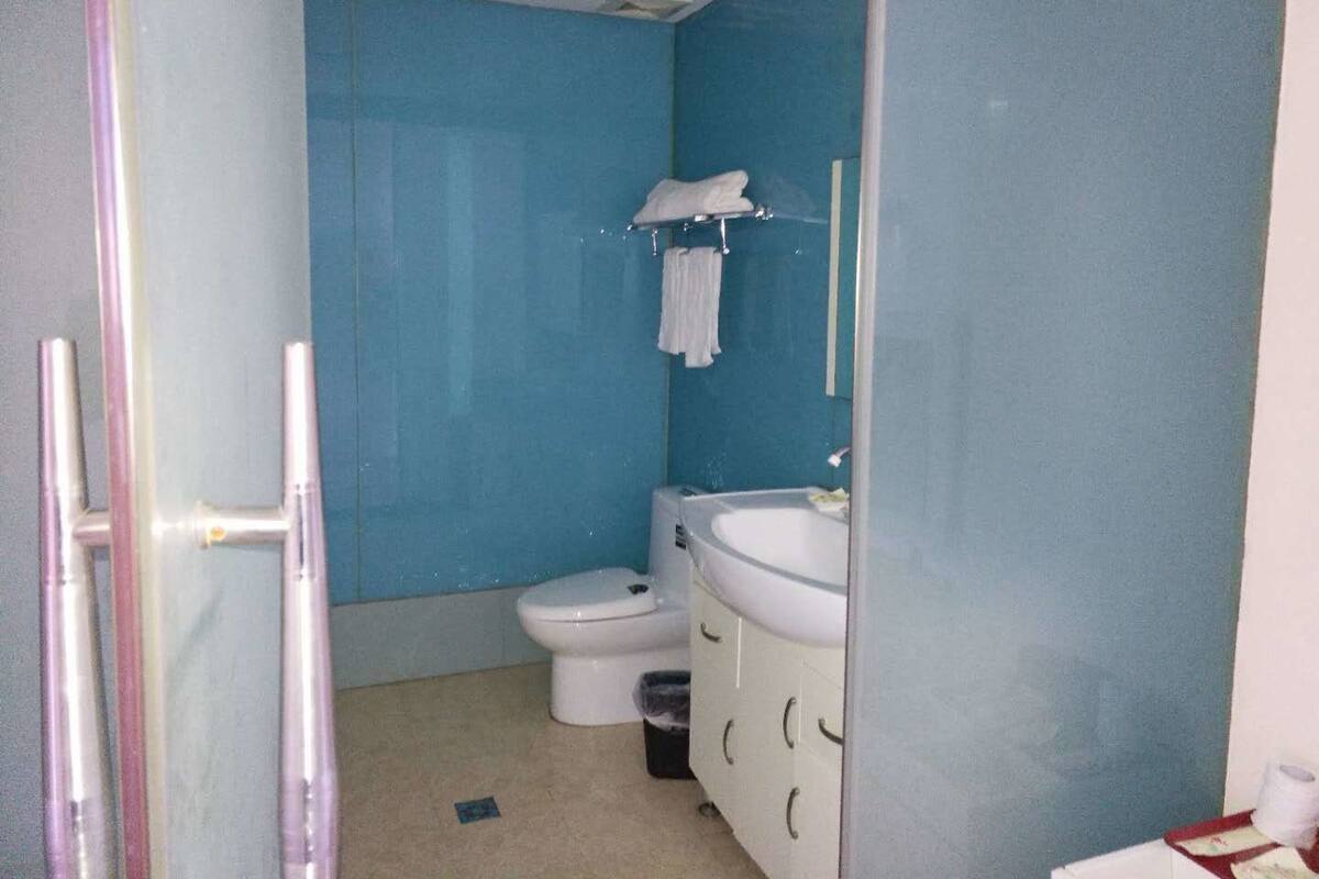 Un baño pequeño con inodoro, lavamanos y espejo.