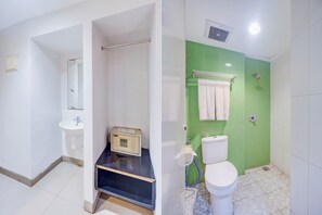 A bathroom with a white sink, a toilet, and a shower area. - Collection O Manggis Inn (Jakarta)