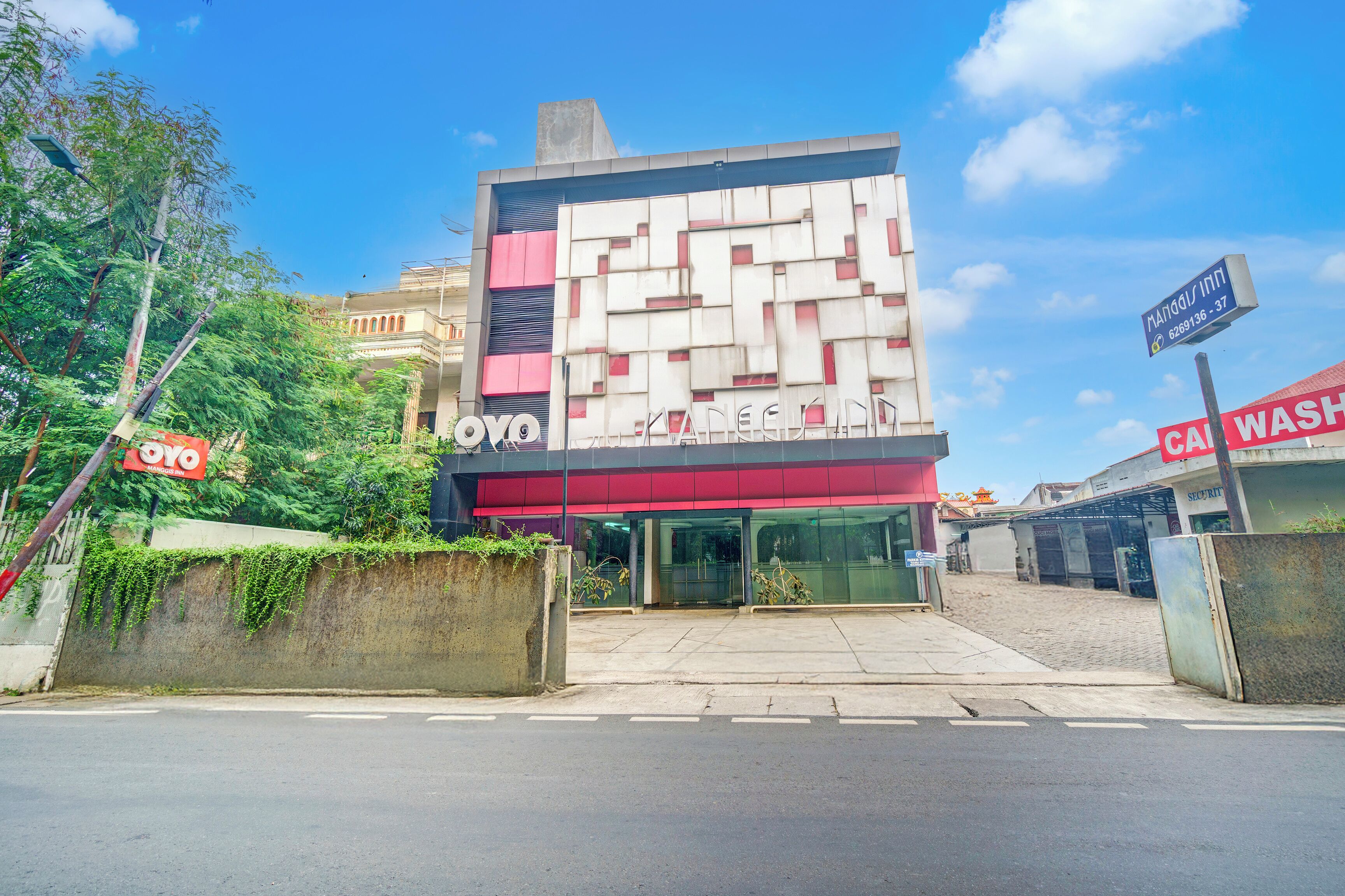 Un bâtiment doté d’une façade moderne, d’une entrée bien visible et d’une enseigne indiquant la présence d’un lave-auto à proximité.