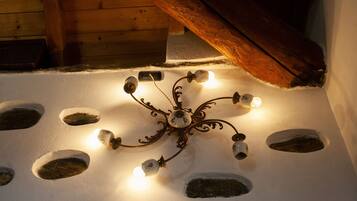 A ceiling with a decorative light fixture and several holes in the plaster.