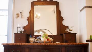 A wooden dresser with a mirror above it, drawers, and a countertop with a glass and a basket.