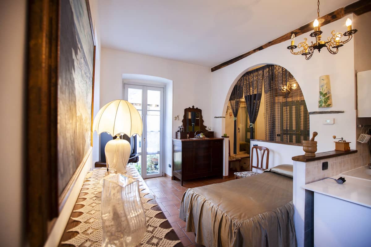 Une chambre à coucher avec un lit, une commode, un miroir et un lustre.
