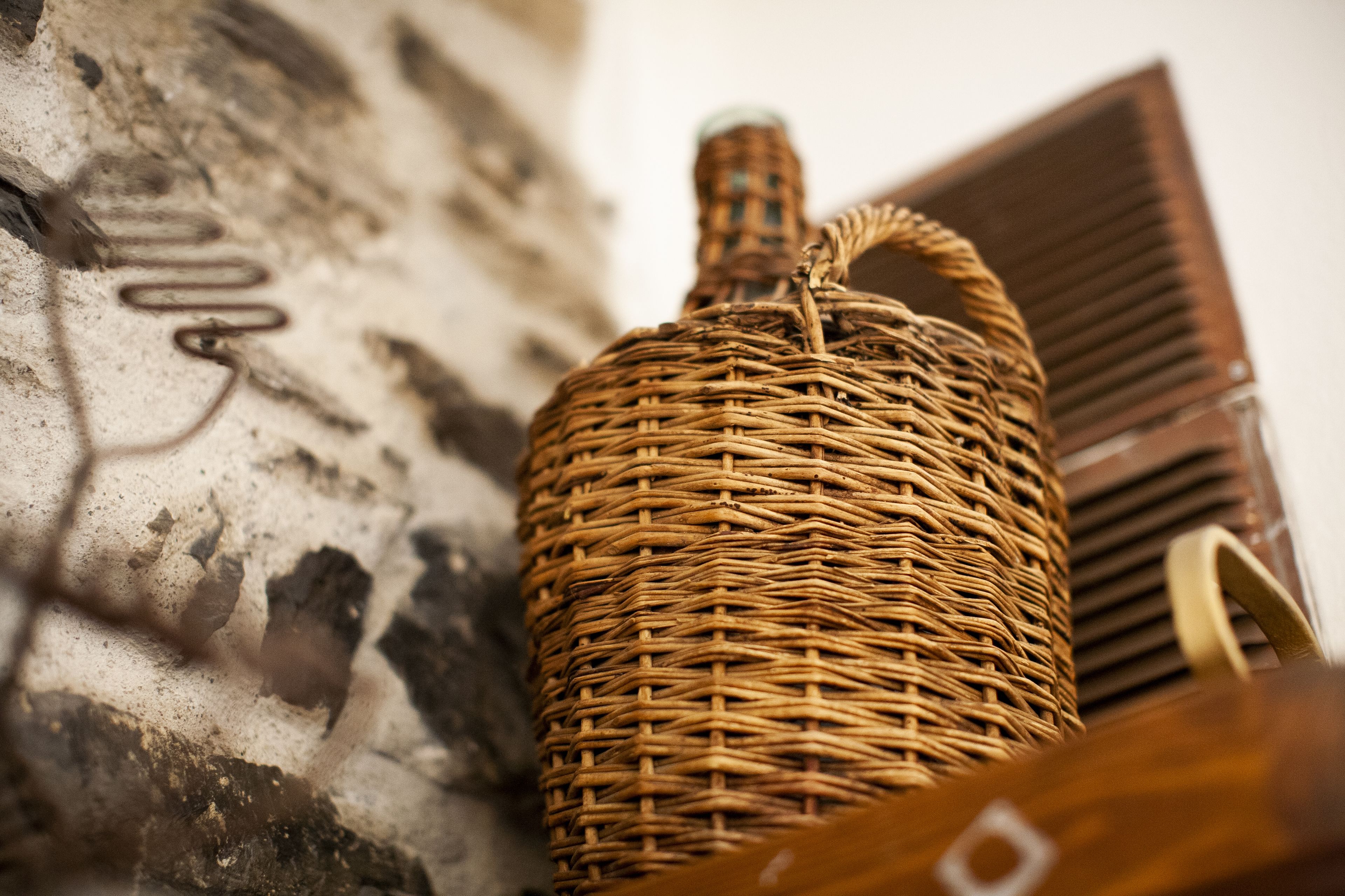A wicker basket against a textured wall.